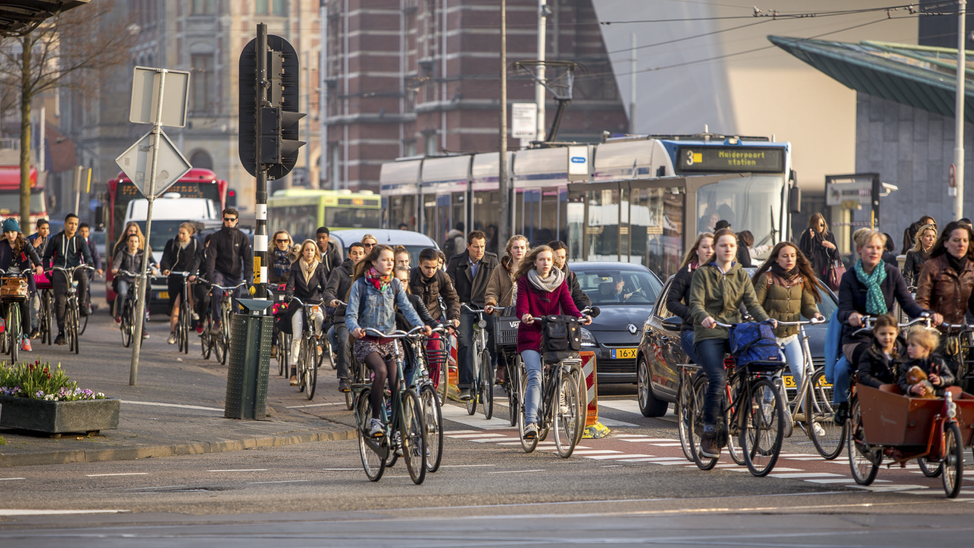 People, man and women cycling on a busy street.