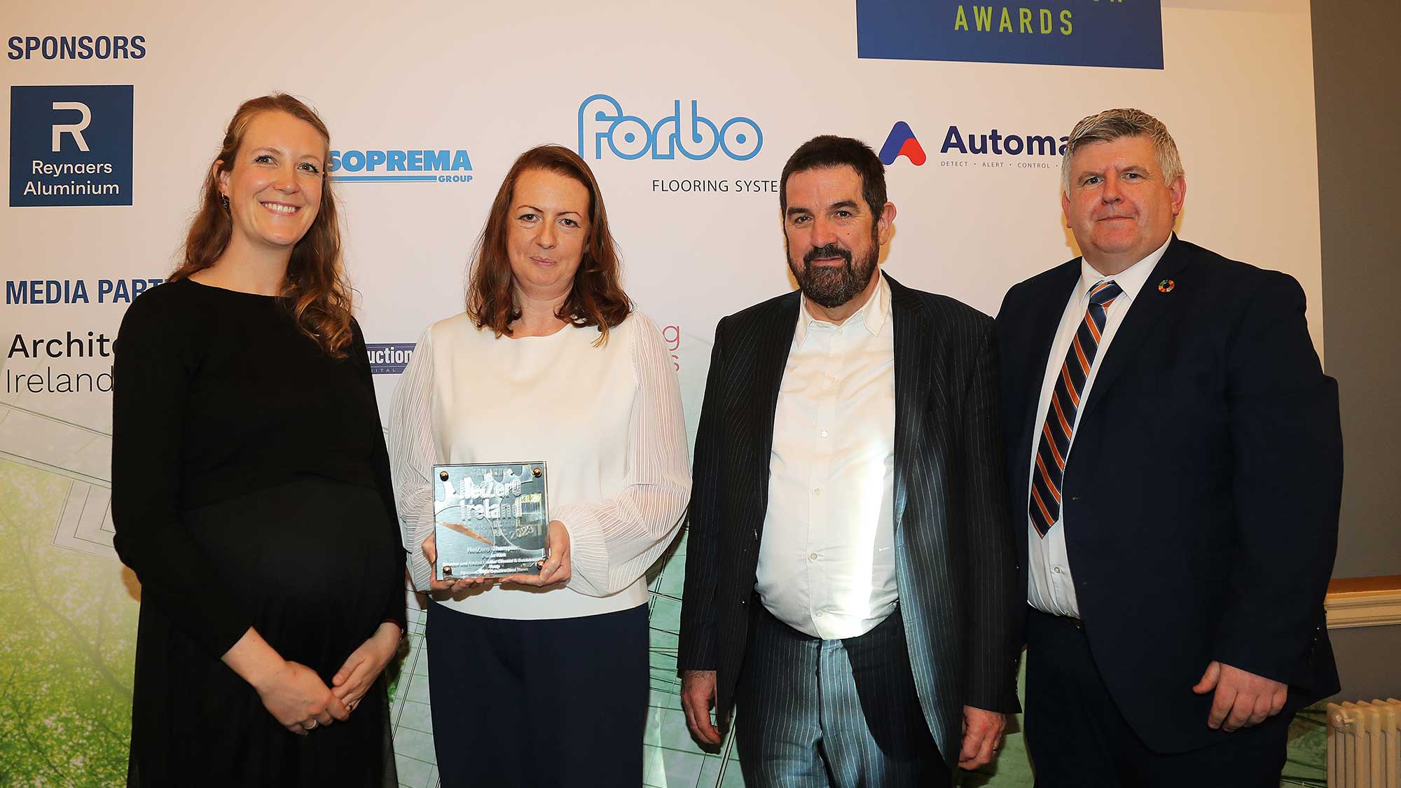 Photograph of Paula Kirk receiving her NetZero Champion Award. Other people in the photo are Mona Duff, Senior Manager at International WELL Building Institute (IWBI) and Past Chair of CIBSE Ireland, Robbie Cousins, Editor of Irish Construction News, sponsor of this award, and Michael Curran, Chair of the panel of judges.