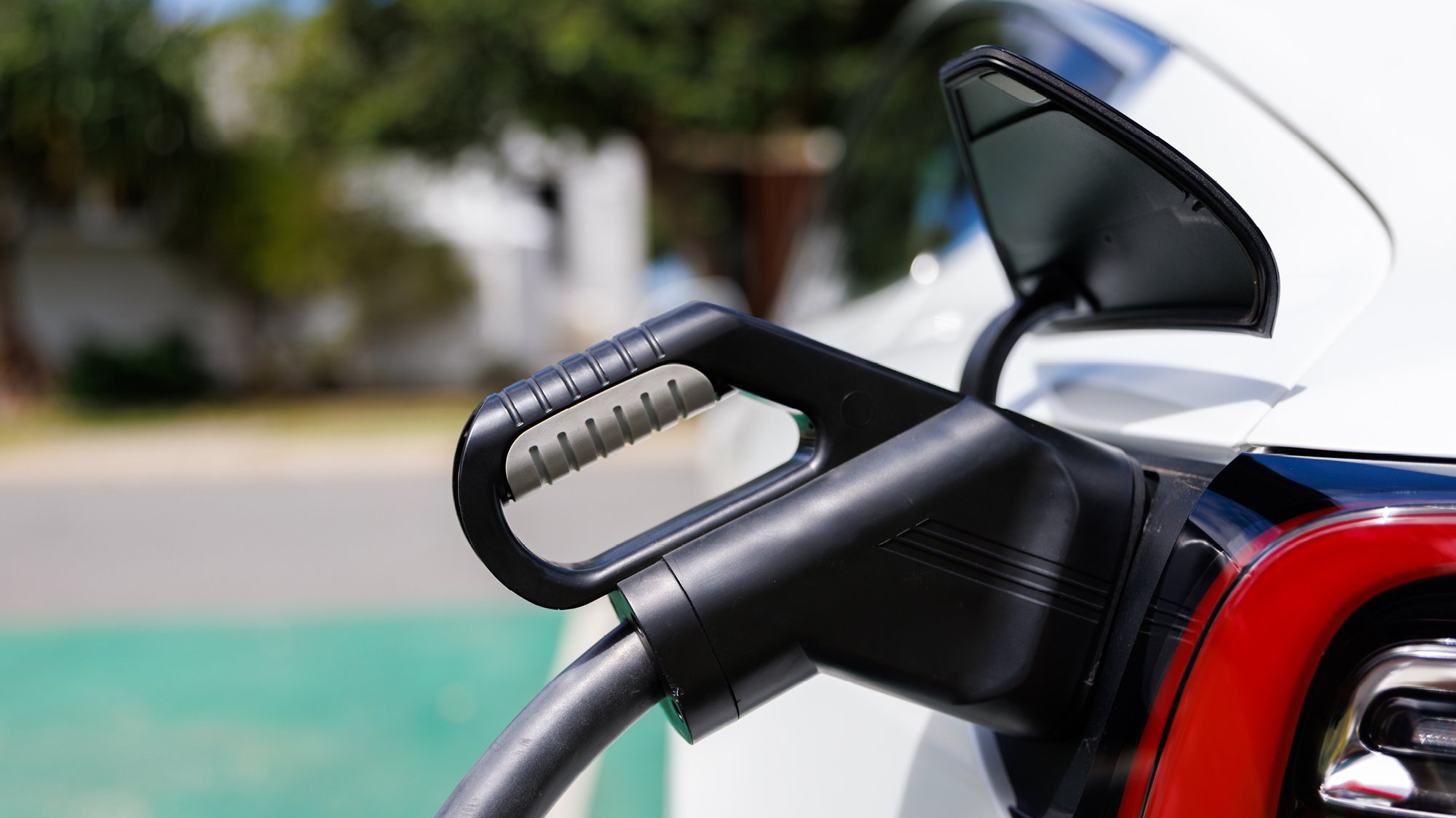 close up view of a white electric vehicle being charged