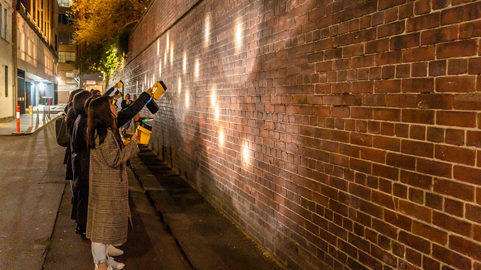 People with torches assessing night time lighting in city