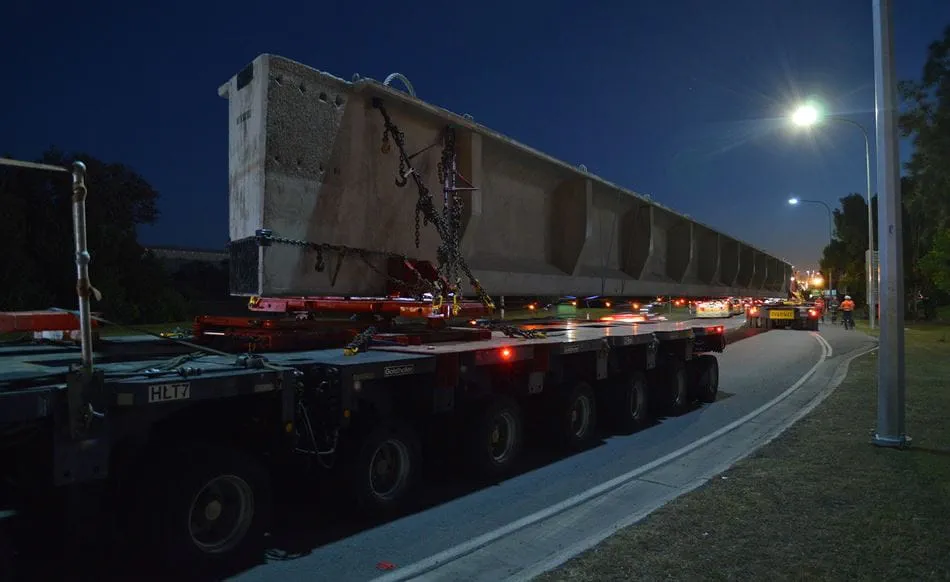 A Quickcell Super I Girder being transported by truck at night