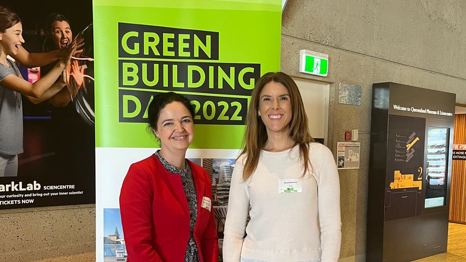 Two women smiling and stadning in front of a sign saying Green Building Day 2022