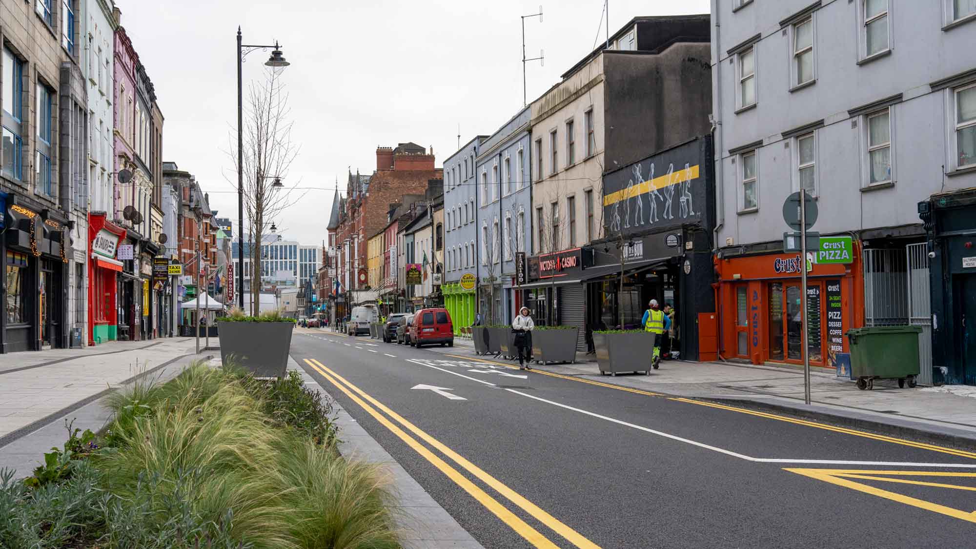 Photograph of the MacCurtain Street Public Transport Improvement Scheme showing two-way traffic, widened pedestrian footpaths and new greenery.
