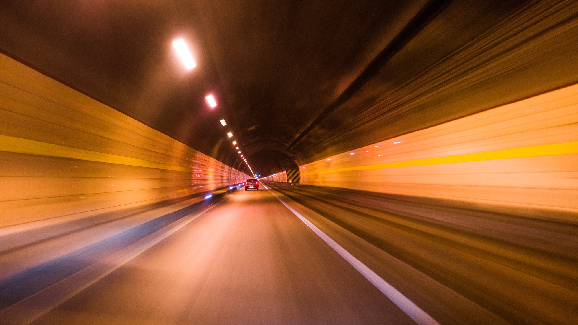 A photograph in side a tunnel speeding along behind a car