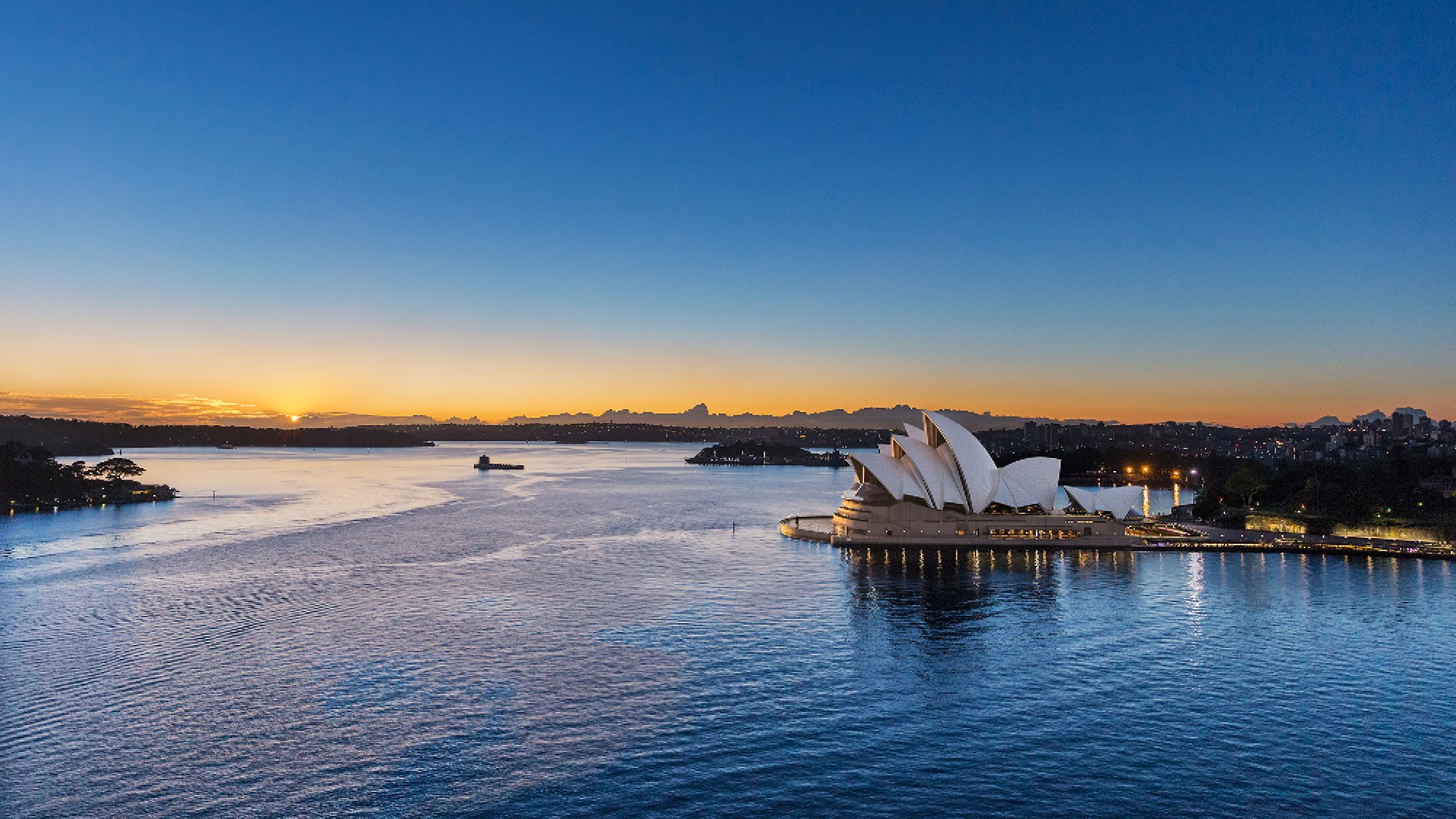 View of the Sydney Opera House and harbour and surrounds at dusk
