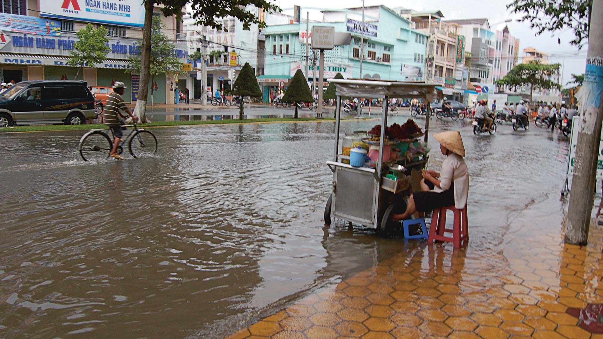 Flooded street scene with vendor in water