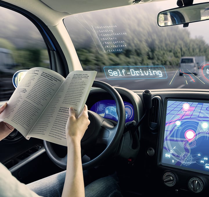 Driver sitting and reading a book in autonomous car