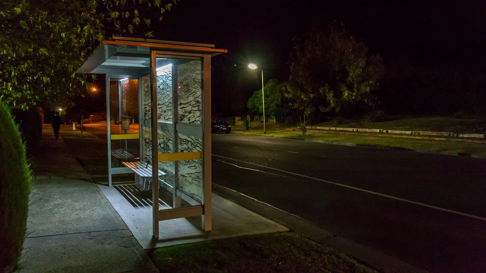 An empty bus stop in a suburban street at night time
