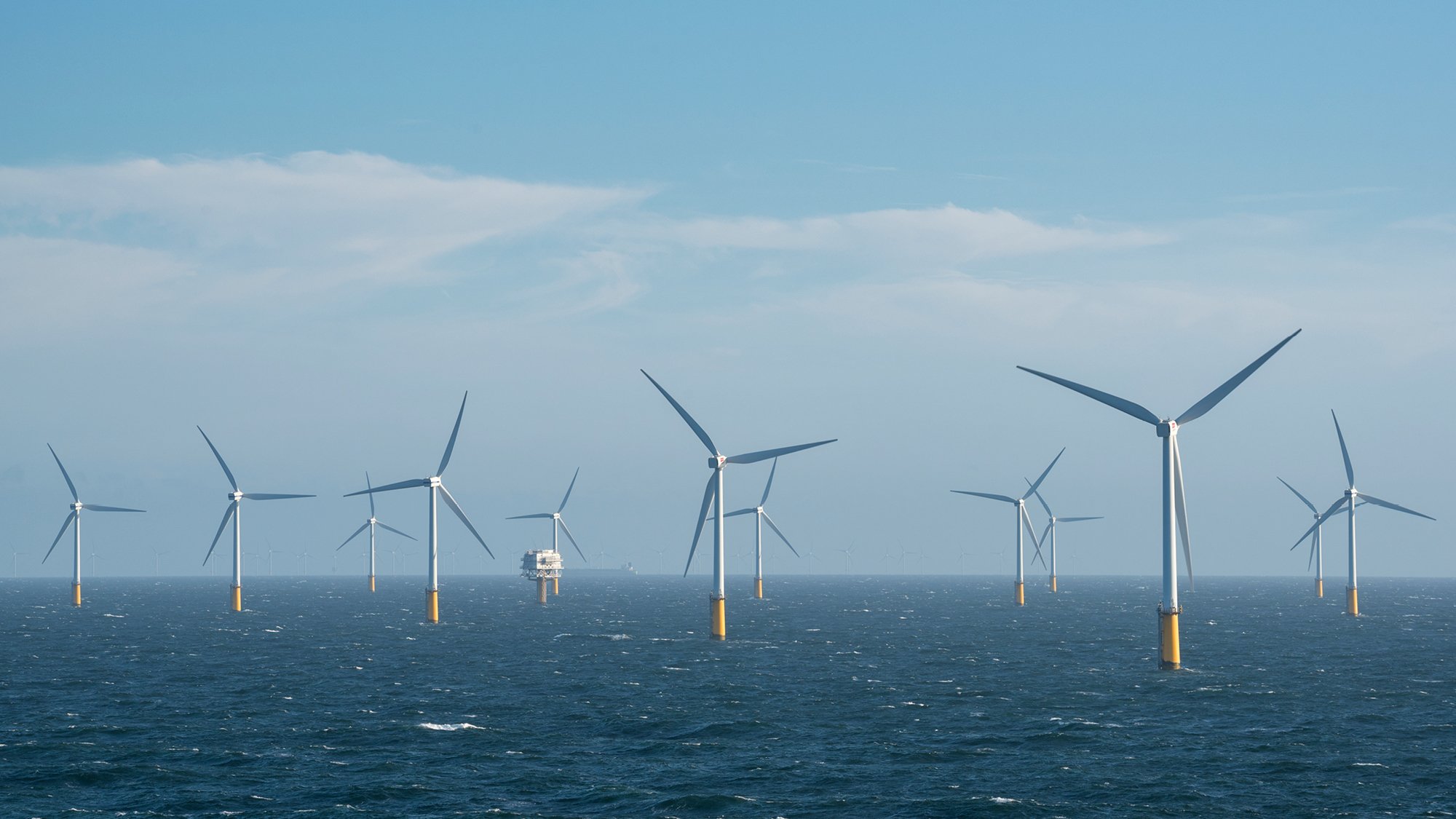 A group of wind turbines in the ocean at an offshore wind farm