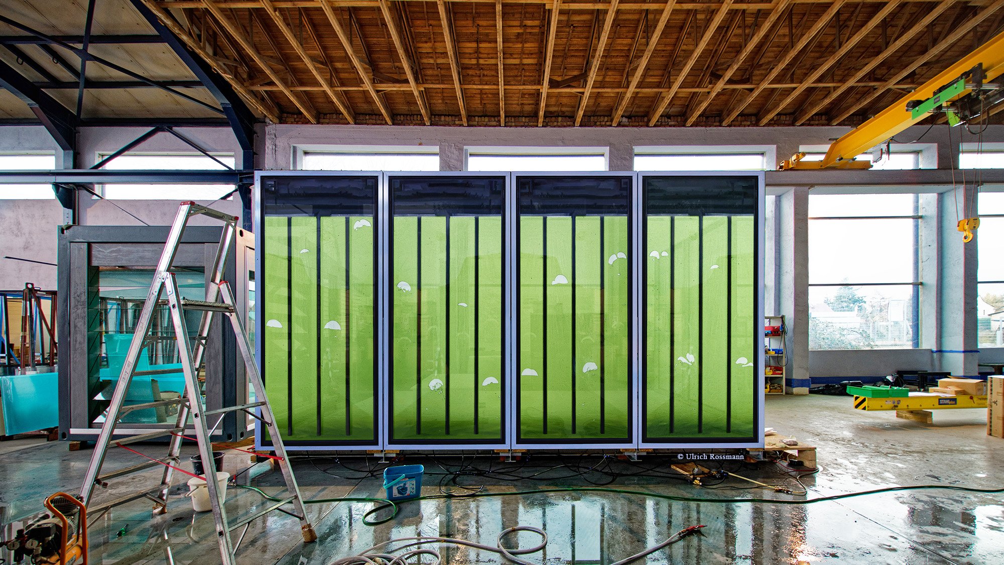 Die Glaselemente der Bioenergiefassade sind Teile einer solarthermischen Anlage, mit der zusätzlich Mikroalgen zum Aufbau von Biomasse und zur Absorption von C02 gezüchtet werden. 