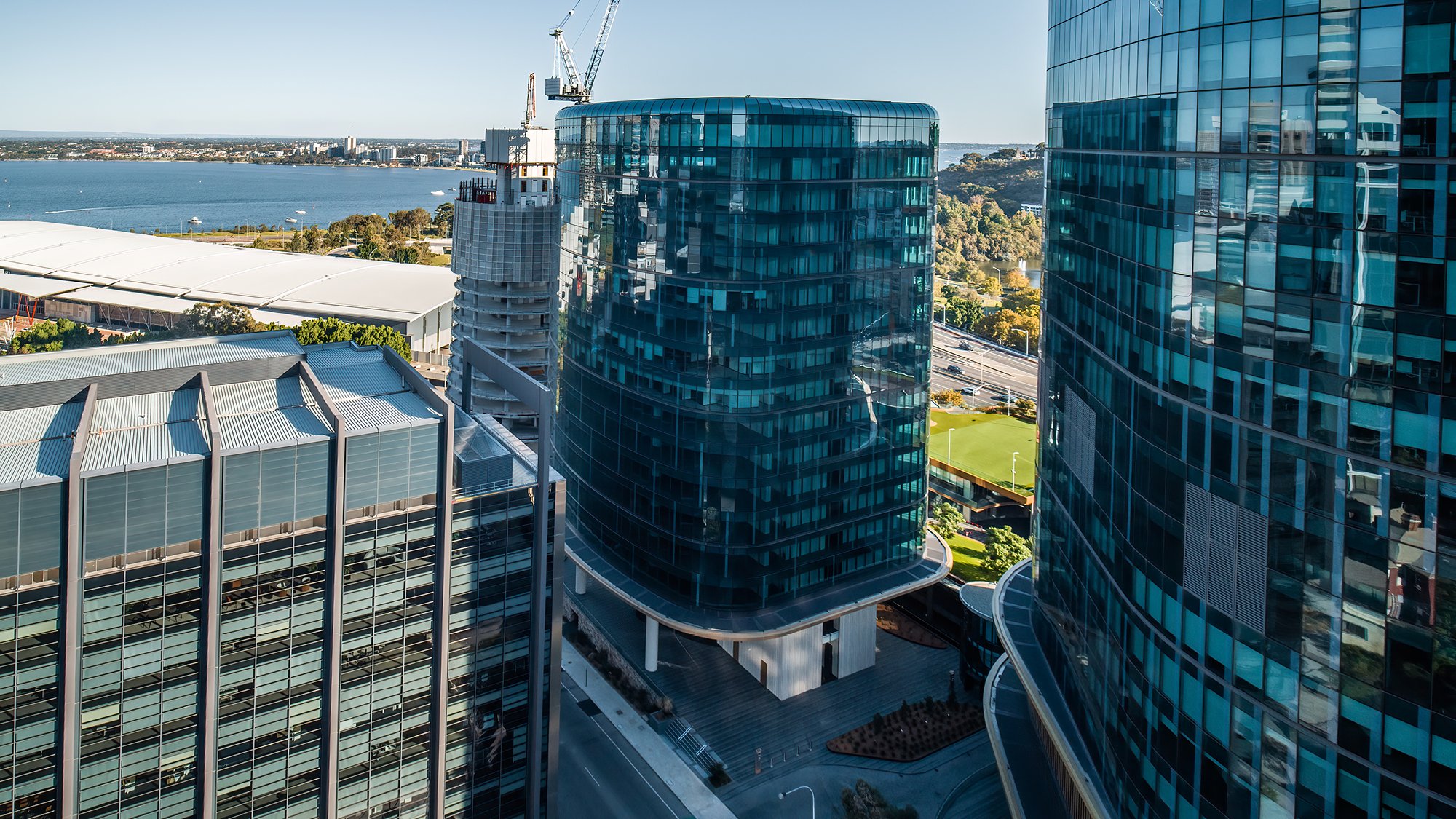 Photograph looking over an office tower of 15 storeys to the land and bayswater behind