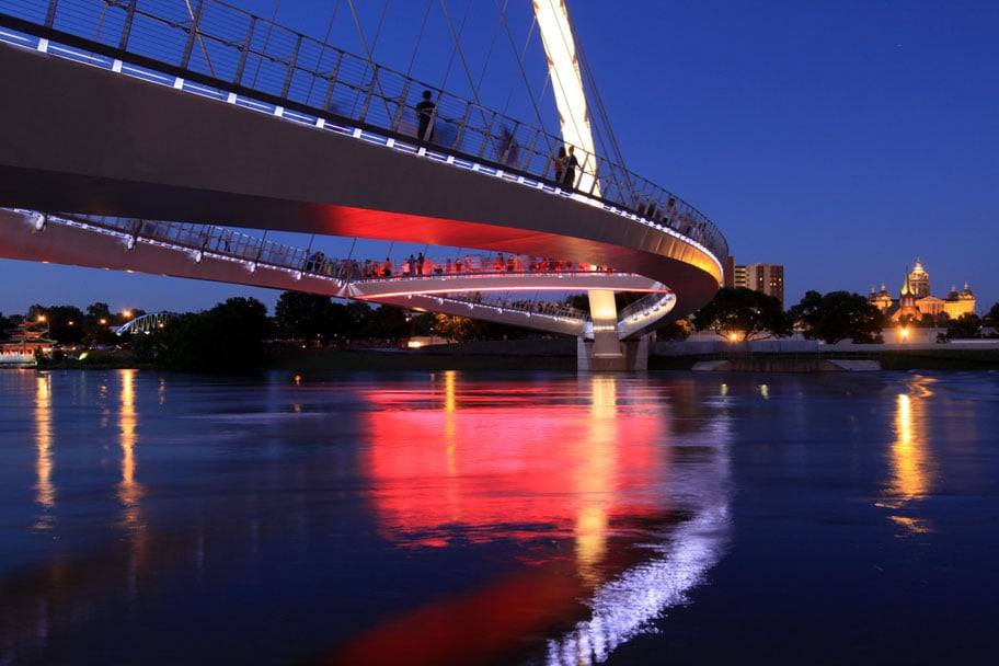 The lighting of Center Street Bridge reflected in the Des Moines River.