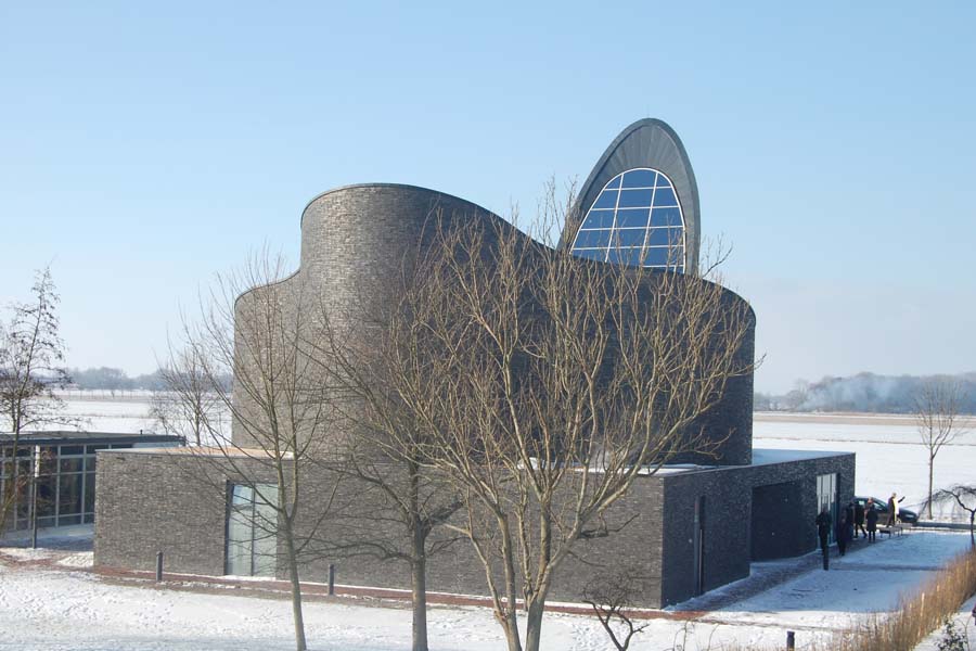 The undulating form of the church complements the surrounding dunes and waves.