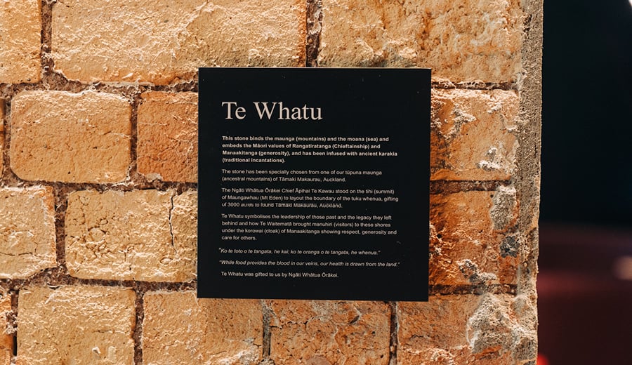 Māori signage on a plaque on a brick wall in an office