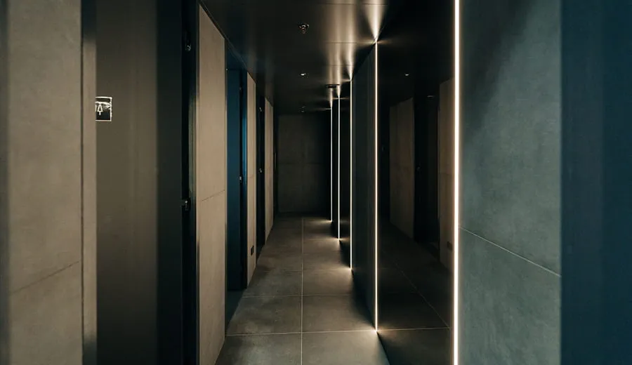 Modern stylish hallway with hiiden doors to bathroom and shower cubicles in dark grey, hidden lighting