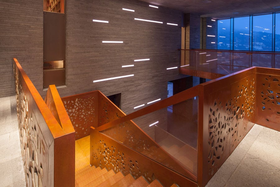 The use of backlighting accentuates the perforations of the composite panels, and dramatic lighting from above reveals the texture and detail of the copper and laminated wood.  