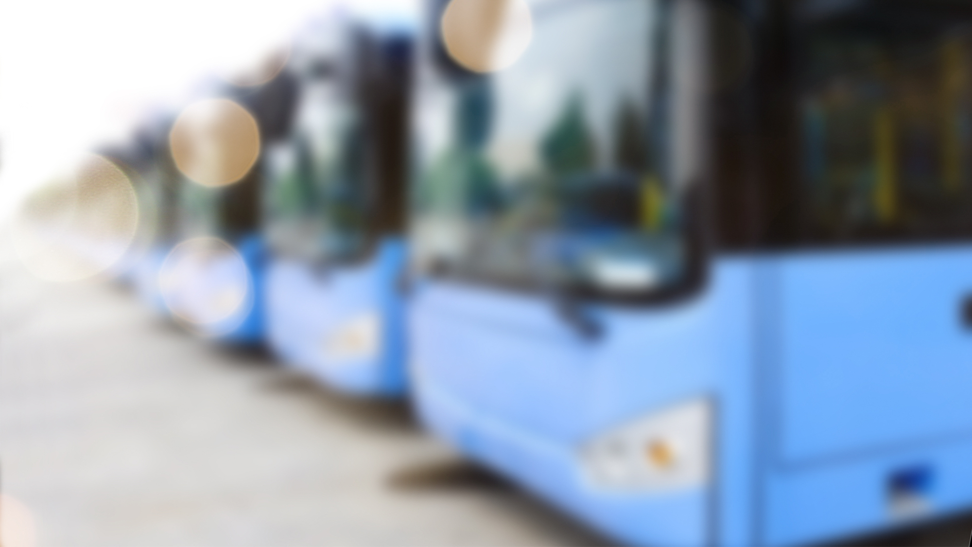 Blurred image of electric buses parked at charging depot