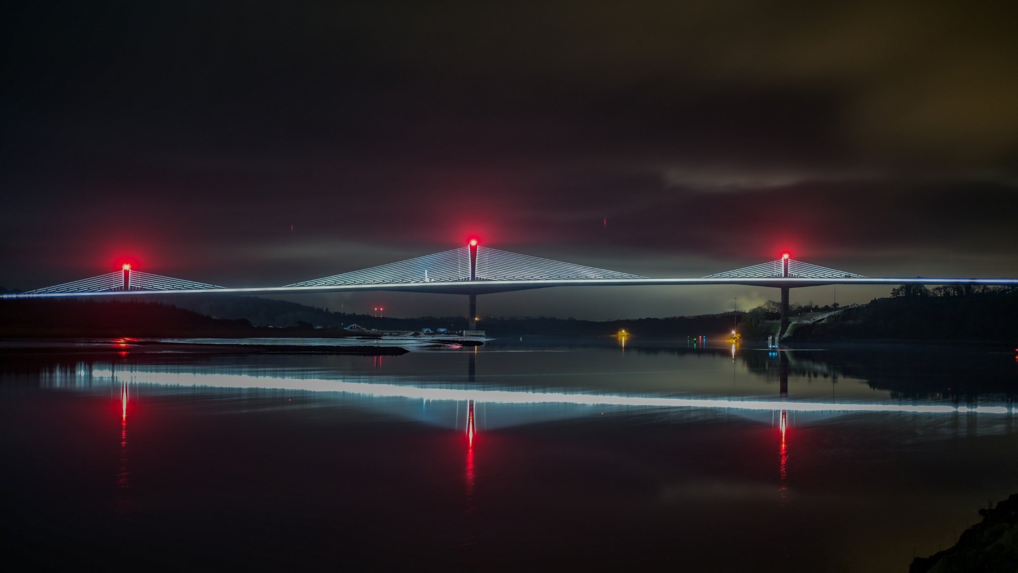View of the Rose Fitzgerald Kennedy Bridge lit-up by night with the lights reflected in the water of the River Barrow.