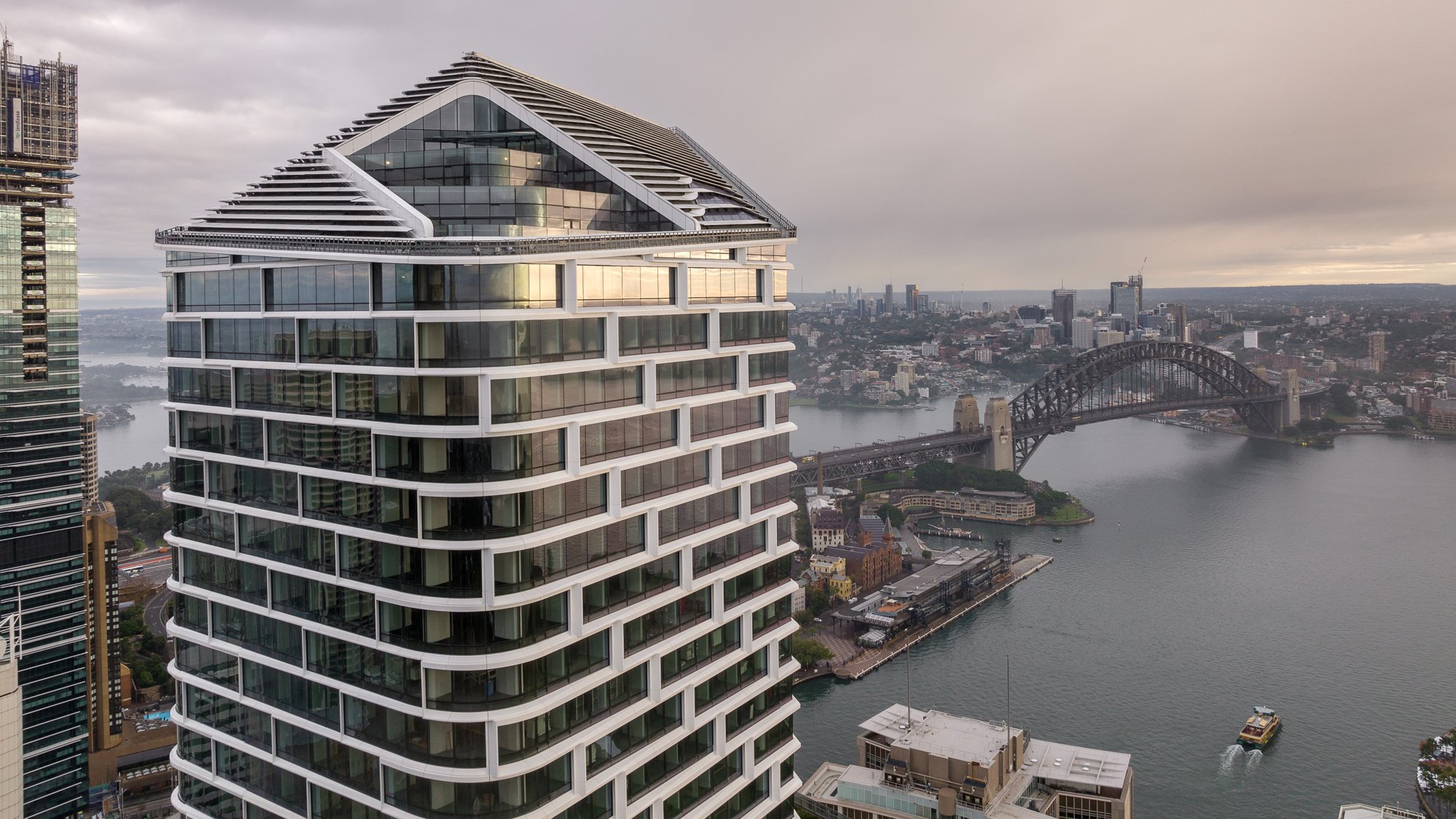 View of top of Quay Quarter Tower, a sustainable building design, at Circular Quay looking over Sydney Harbour Bridge
