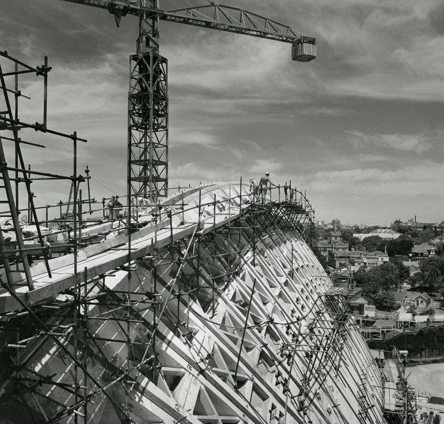 The Sydney Opera House under construction with workers undertaking construction on the roof © Max Dupain
