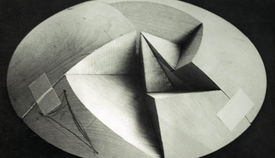 An archival photograph of a wooden sphere shape with sections cut out