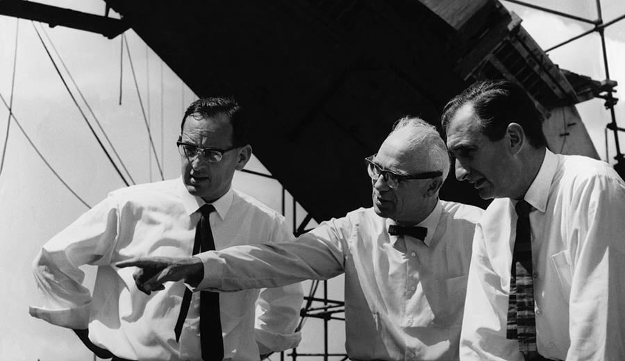 Black and white photograph of Michael Lewis, Ove Arup and Jack Zunz at the Sydney Opera House contruction site in 1966