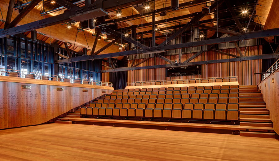 Inside a new theatre for orchestra performance at Walsh Bay Arts Precinct. The theatre has folding seating, high ceilings, timber furnishings and panels.