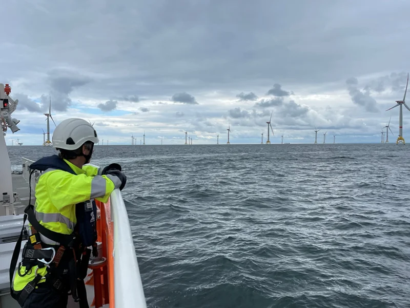 Man on a boat approaching an offshore wind farm