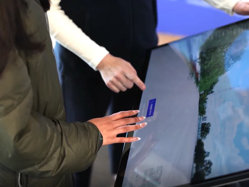 People looking at a digital information terminal