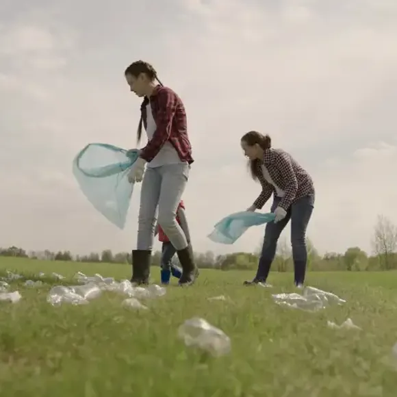 A man and woman walking in a field of grass.