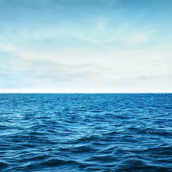 A body of water with a blue sky and clouds.