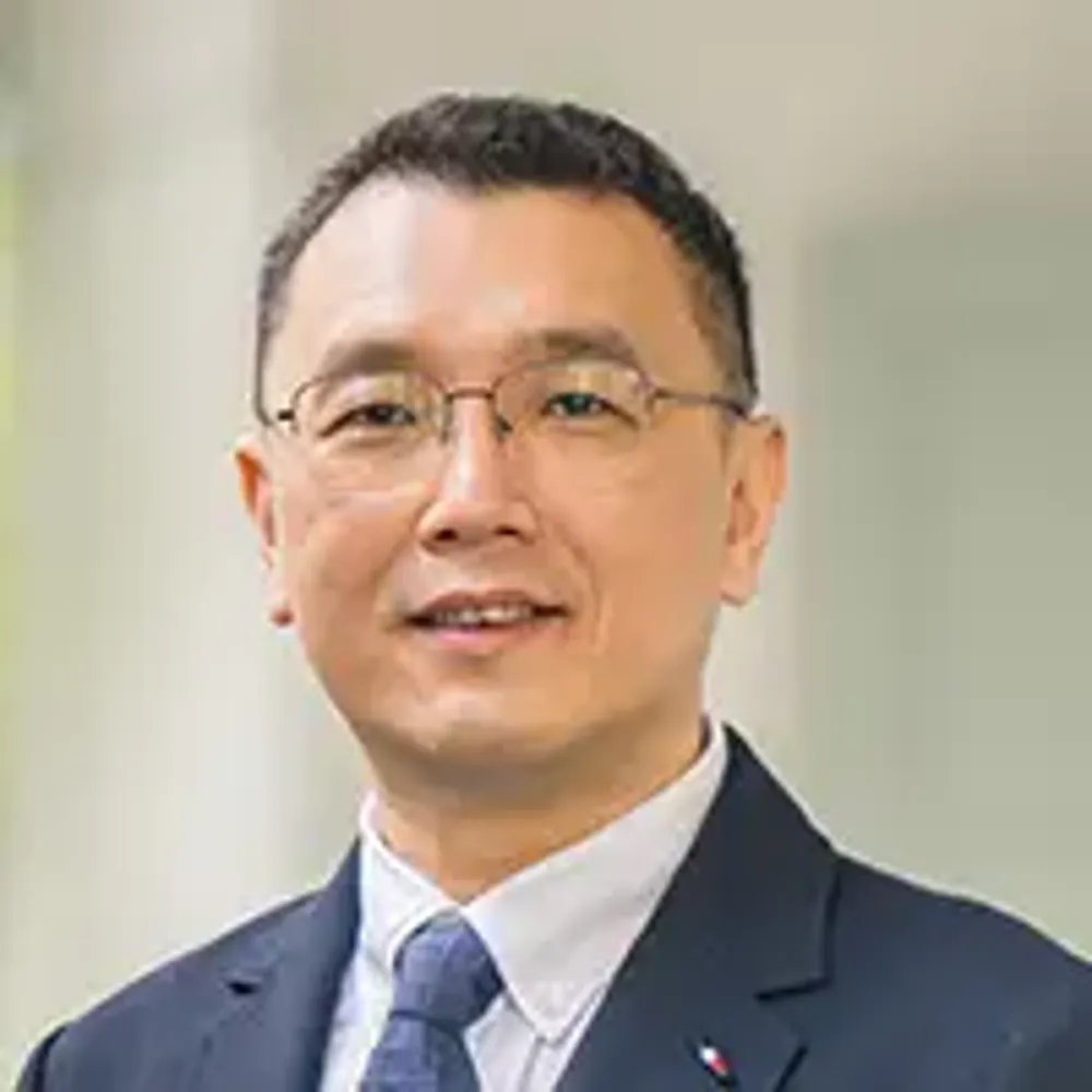 A man wearing glasses and a suit.