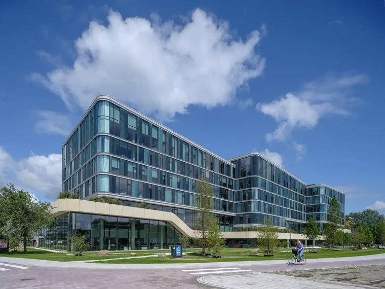 A large building with a few people in front of it.
