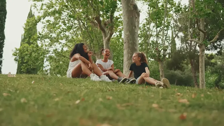 A group of people sitting on the grass.