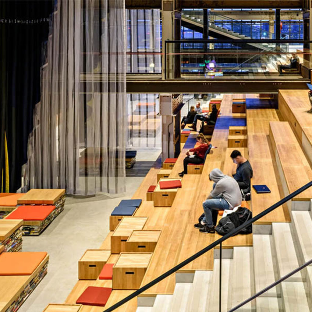 People sitting on the stairs in a library