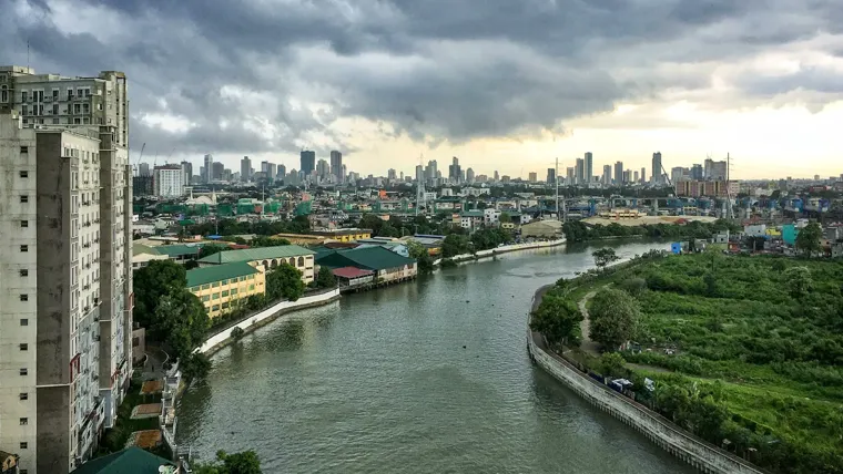 A river with buildings and trees by it.