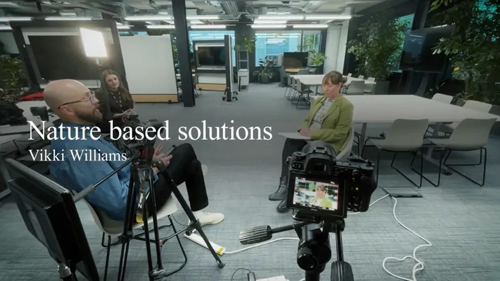 A group of people sitting at a table with a camera.