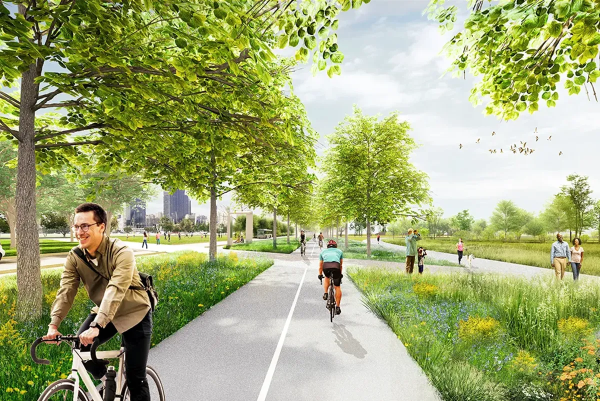 A person riding a bicycle on a road with people on the side.
