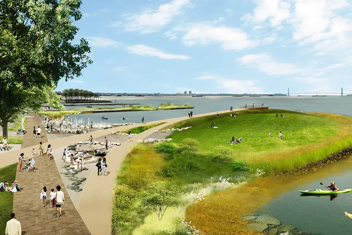 A group of people walking on a path by a body of water.