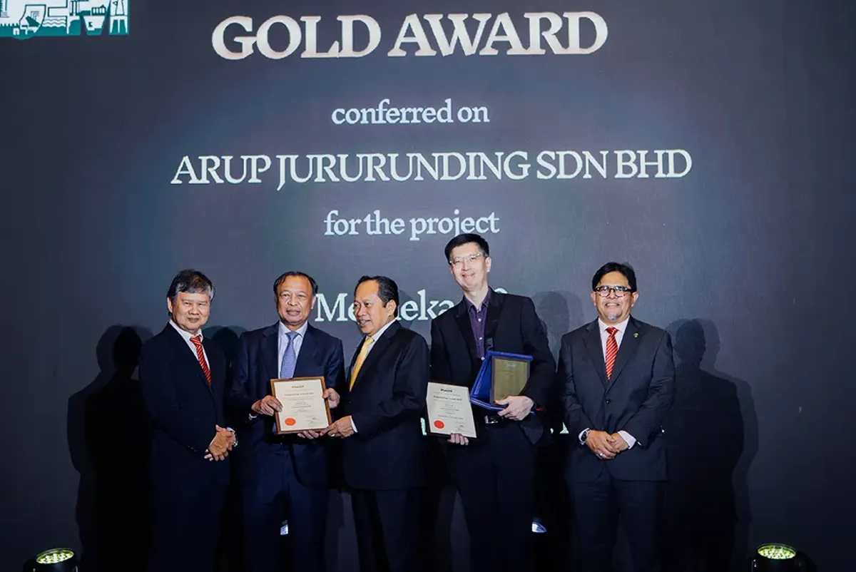 A group of people holding certificates in front of a media wall