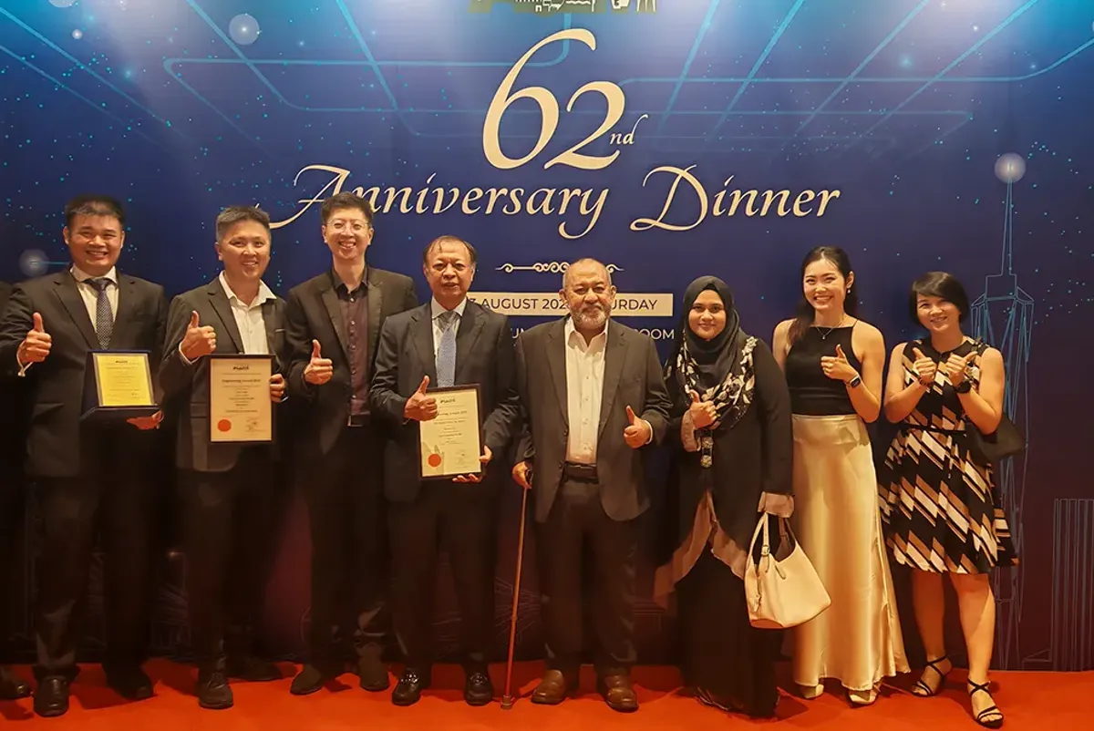 A group of people holding certificates in front of a media wall