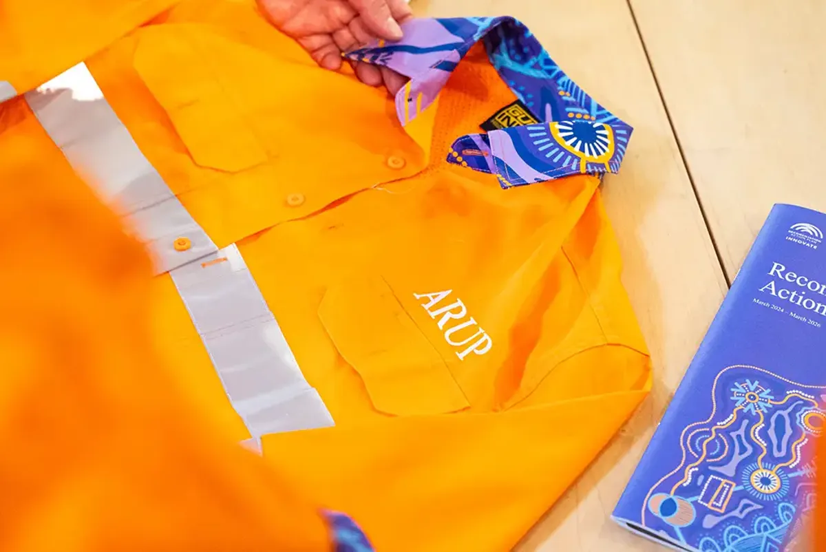 A high visibility, bright orange shirt with Arup logo, featuring Aboriginal artwork