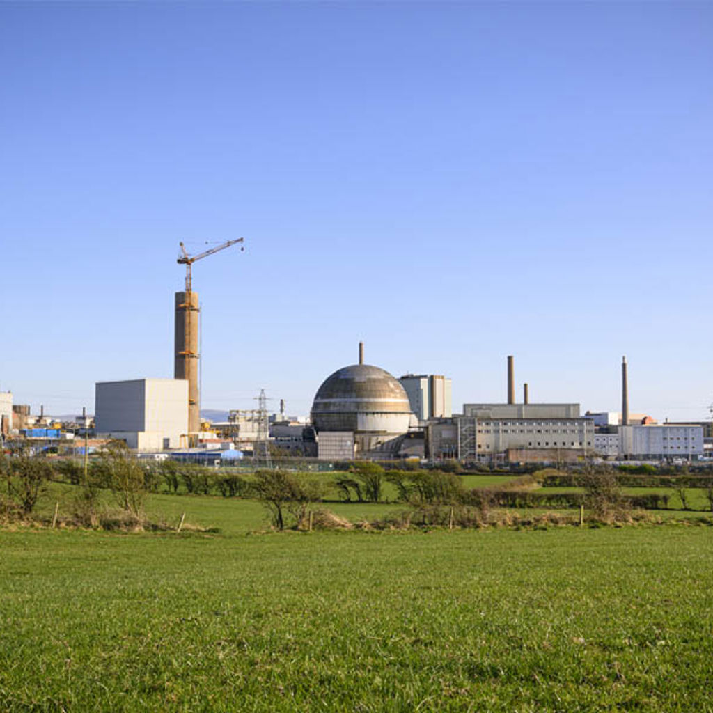 A field with buildings in the background.