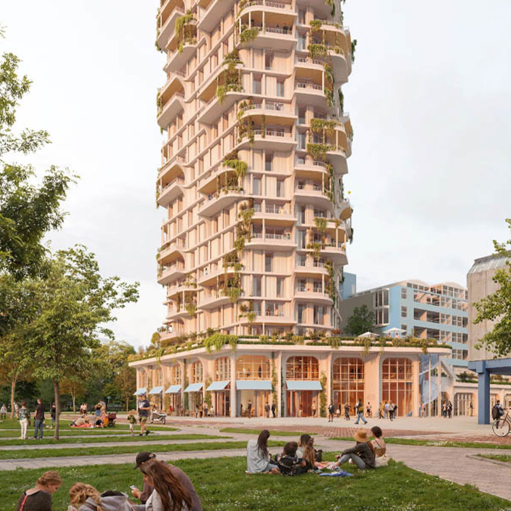 A tall building with people sitting on the grass in front of it.