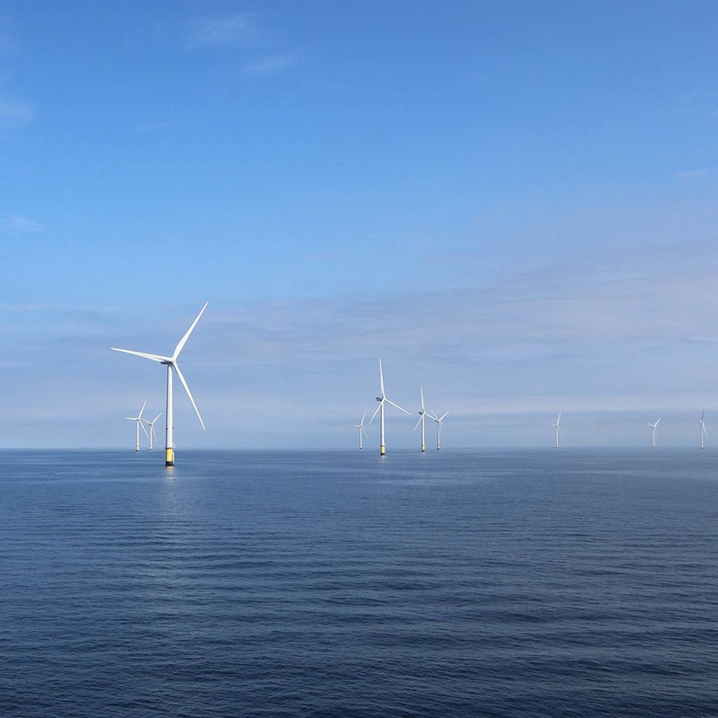 A group of wind turbines in the water.