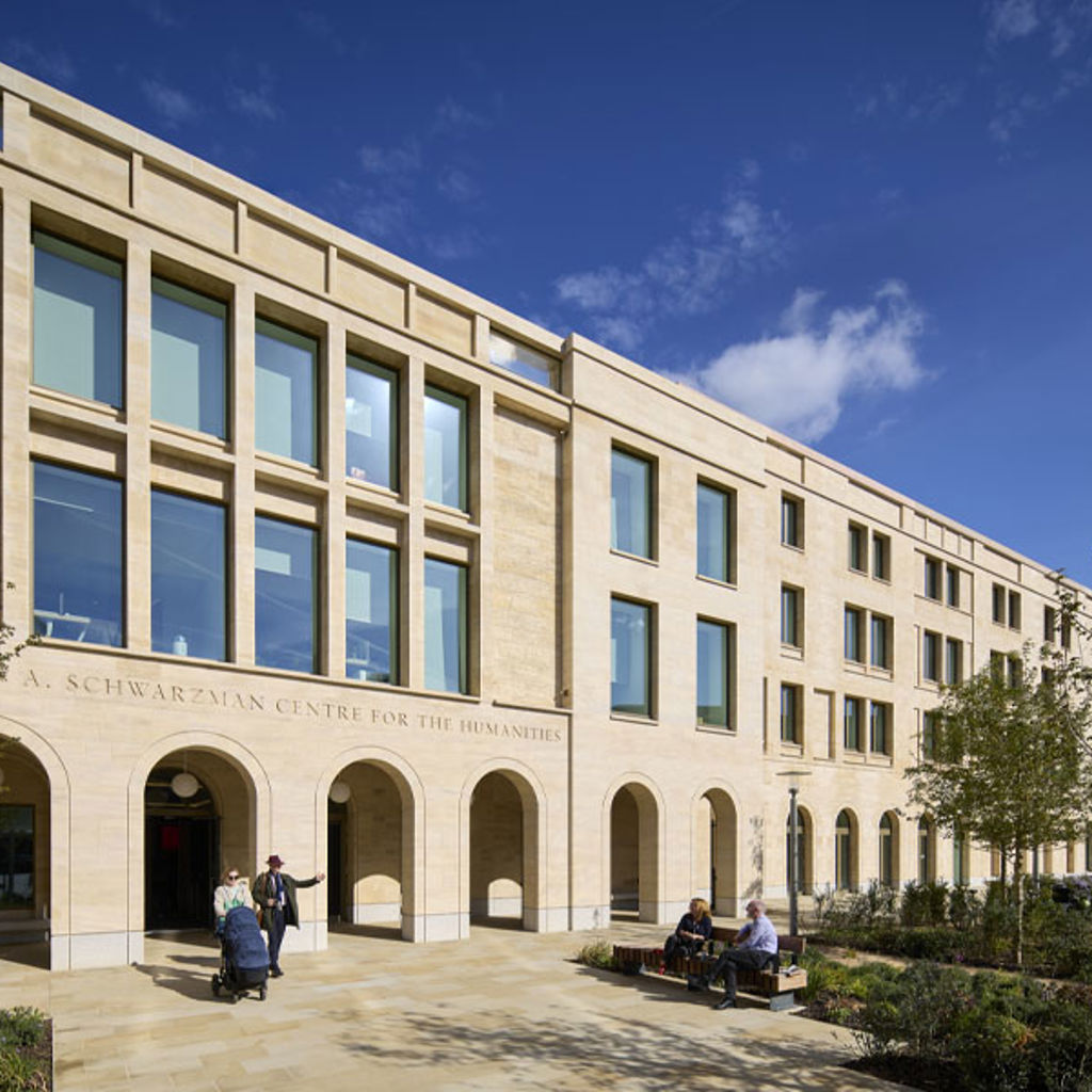 Entrance to the Schwarzman Centre at the University of Oxford, with people sitting outside.