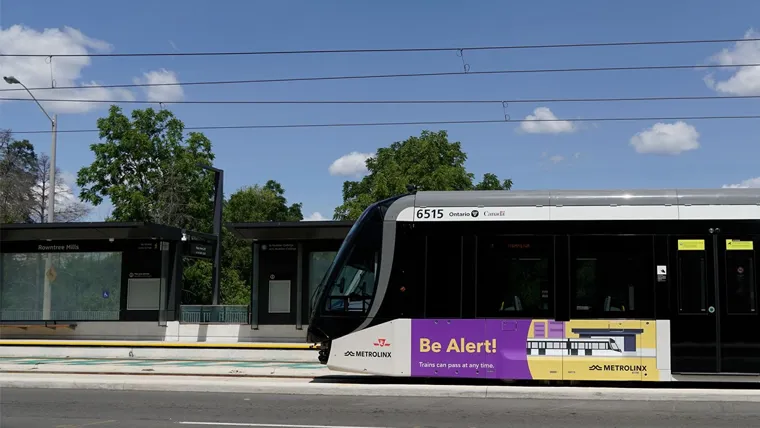 Side view of a light rail train traveling at grade