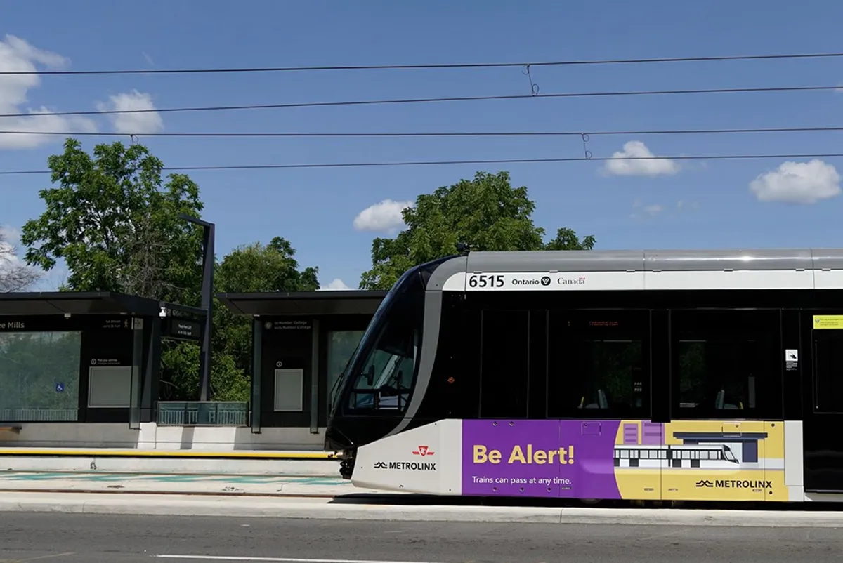 Side view of a light rail train traveling at grade
