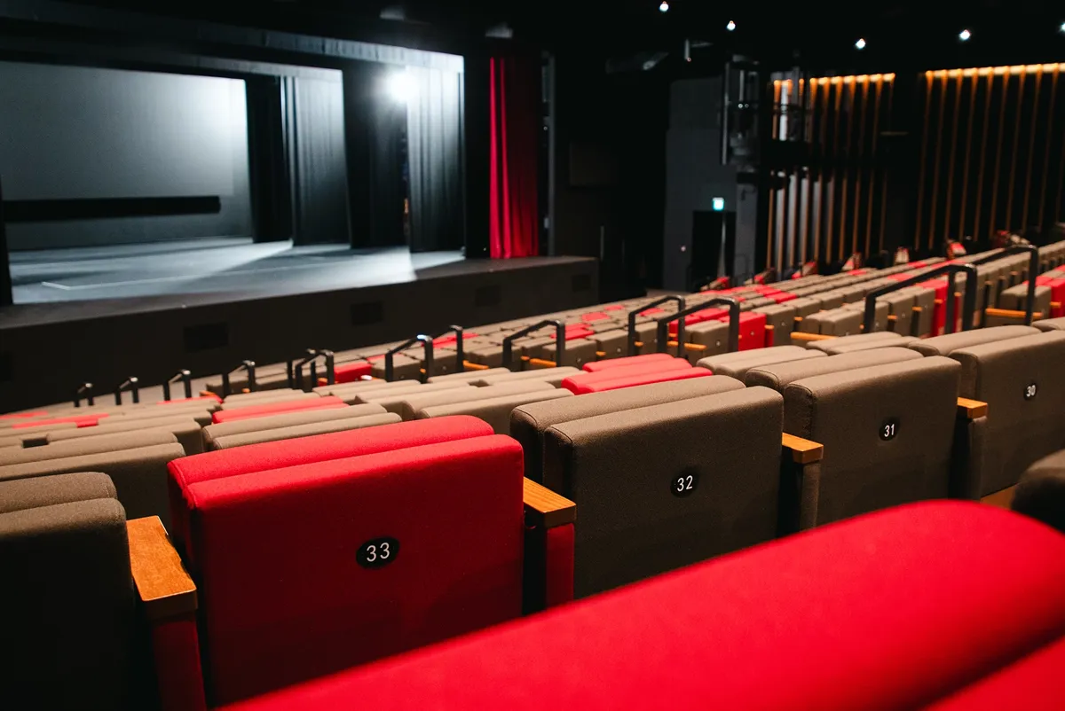 A large room with red chairs.