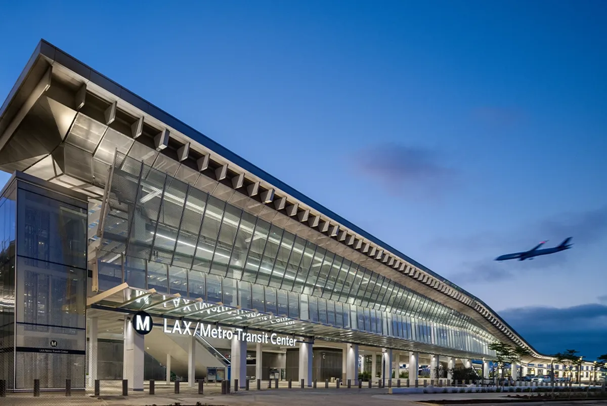 A large building with a plane flying by.